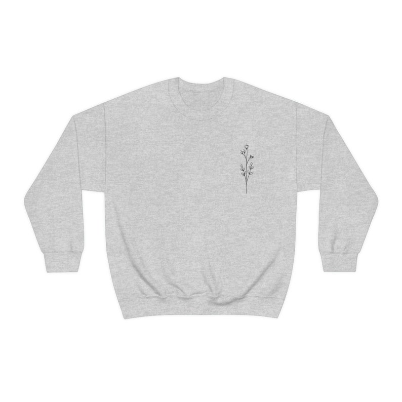 May include: A heather gray sweatshirt with a small, simple line drawing of a flower on the left chest.