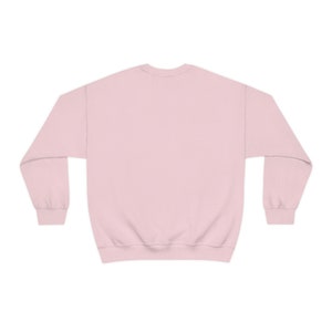 May include: A plain pink sweatshirt with long sleeves and a crew neck.