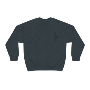May include: A dark heather grey sweatshirt with a small black floral design on the left chest.
