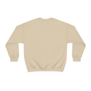 May include: A plain, light beige sweatshirt with long sleeves and a crew neck.