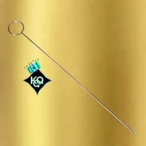 May include: A silver needle threading tool with a circular loop at the top and a sharp point at the bottom.