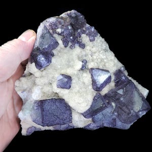 May include: A set of three ceramic mugs with a speckled, matte finish. The mugs are in shades of cream, light gray, and dark gray. Each mug has a simple, minimalist design and a rounded handle.