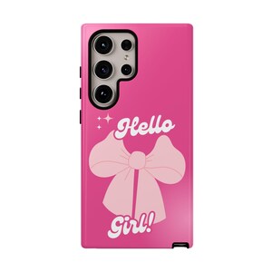 May include: A bright pink phone case featuring a large bow graphic and the words "Hello Girl!" in white script. The case has a camera module and buttons on the side.