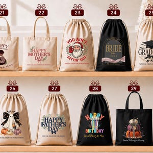 a collection of bags and drawstring bags with various designs and messages, including "Happy Mother's Day", "You Ain't", "Graduate", "Bridal", "Happy Father's Day", and "Happy Birthday".