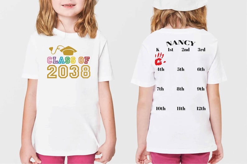 K&ouml;nnte beinhalten: Wei&szlig;es T-Shirt mit einem Regenbogen-Design "CLASS OF 2038" auf der Vorderseite und einem Handabdruck sowie den Klassenstufen von der Vorschule bis zur 12. Klasse auf der R&uuml;ckseite. Der Text "NANCY" ist &uuml;ber den Klassenstufen gedruckt.