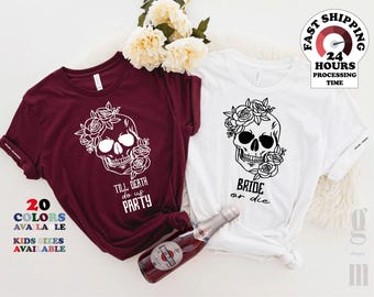 May include: A maroon t-shirt with a white graphic of a skull wearing roses and the text "TILL DEATH do us PARTY" and a white t-shirt with a black graphic of a skull wearing roses and the text "BRIDE or die" with a bottle of Martini sparkling wine.