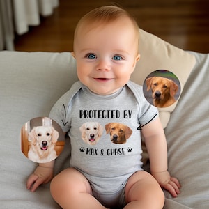 May include: A gray baby onesie with the text "PROTECTED BY" and two dog photos with the names "Max & Chase" printed on it. A baby is wearing the onesie and smiling.