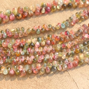 Peut inclure: Un brin de perles de tourmaline multicolores. Les perles sont rondes et ont une finition lisse et polie. Les couleurs des perles comprennent le vert, le rose et le rouge.