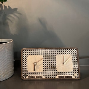 May include: A wooden clock with a woven pattern and two clock faces. The clock faces show the time in Hong Kong and the United Kingdom.