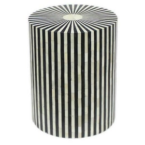 Może przedstawiać: Cylindryczny stołek w czarno-białe pasy wykonany z intarsji kostnej. Górna część stołka ma wzór w kształcie słońca.