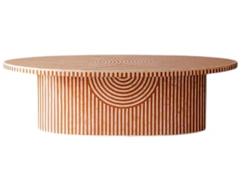 Pode incluir: Uma mesa de centro redonda com acabamento castanho claro. A mesa apresenta uma base cilíndrica com riscas verticais e um design semicircular. O tampo tem um padrão semelhante. A mesa tem aproximadamente 122 cm de diâmetro.