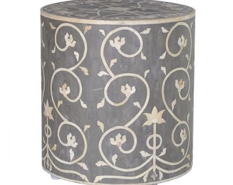 May include: A round gray and white bone inlay side table with a floral design. The table has a smooth surface and a round base.