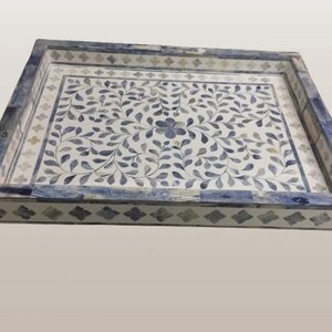 May include: A rectangular serving tray with a blue and white floral design. The tray has a raised border with a geometric pattern.