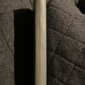 Op de afbeelding: Grijze boekrug met gouden letters. De titel luidt "Problems in Abnormal Behaviour" en de auteur is "Nathaniel Thornton". Het boek staat tegen een donkere, getextureerde achtergrond.