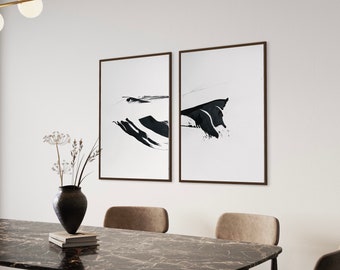 May include: Two black and white abstract art prints in brown frames hanging on a white wall above a black marble table with two chairs.