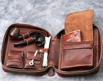 May include: A brown leather pipe tobacco pouch with a zipper closure. The pouch is open and contains two pipes, a pack of tobacco, and pipe cleaners. The pouch has multiple pockets and compartments.