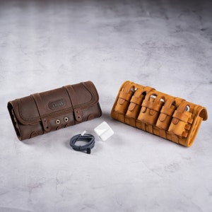 May include: Two leather pouches for carrying electronics. The brown pouch has the word "Chaus" embossed on it. The tan pouch has multiple pockets for cords and chargers.
