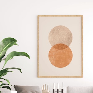Könnte beinhalten: Ein Wohnzimmer-Interieur mit einem weißen Sofa, einem Couchtisch, einer Topfpflanze und einem gerahmten Druck von zwei sich überlappenden Kreisen in Orange- und Beigetönen.