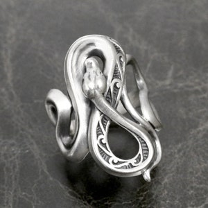 Op de afbeelding: Een zilveren ring met een gedetailleerd slangendesign. De slang is opgerold en heeft een getextureerd oppervlak. De ring is een statement piece en zou een uniek cadeau zijn.
