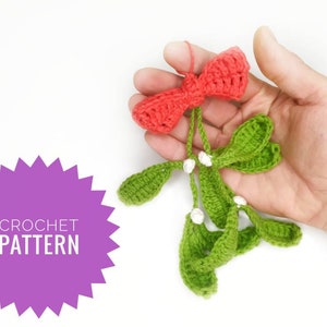 May include: Crochet pattern for a green and white mistletoe sprig with a red bow. The pattern is written in English.