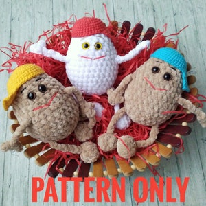 May include: Three crocheted plush toys in a basket. The toys are shaped like eggs with faces and hats. One toy is white with a red hat, one is brown with a yellow hat, and one is brown with a blue hat. The toys are sitting in a basket filled with red shredded paper. The text "PATTERN ONLY" is written in red letters at the bottom of the image.
