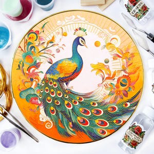 Könnte beinhalten: Eine runde dekorative Platte mit einem Pfauenmuster. Der Pfau hat blaue, grüne und gelbe Federn, umgeben von bunten floralen Elementen. Die Platte hat einen goldfarbenen Rand und einen cremefarbenen Hintergrund.