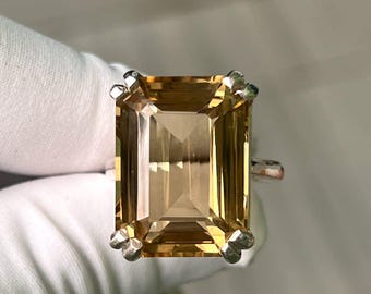 May include: A gold emerald cut gemstone ring set in a silver band.