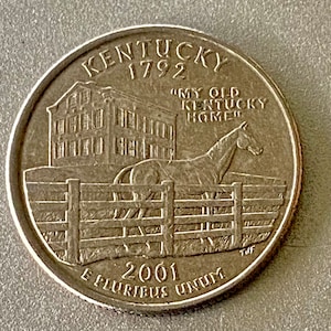 May include: A United States quarter coin featuring the state of Kentucky. The coin depicts a house, a horse behind a fence, and the text "MY OLD KENTUCKY HOME". The coin also includes the year 2001 and the inscription "E PLURIBUS UNUM".