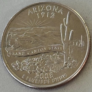 May include: A silver Arizona quarter coin from 2008. The coin features a desert landscape with a rising sun, a saguaro cactus, and the words "Arizona 1912" and "Grand Canyon State". The coin also has the inscription "E Pluribus Unum".