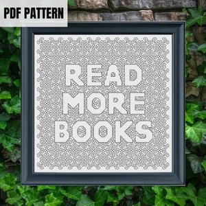 Puede incluir: Patrón de punto de cruz en blanco y negro con el texto "READ MORE BOOKS" en un marco negro.