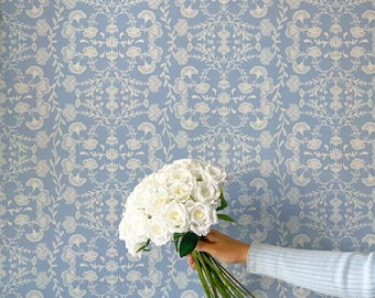 May include: A bouquet of white roses with green stems is held against a light blue floral patterned background. The flowers are the focal point, with the background providing a soft, complementary backdrop. The overall aesthetic is delicate and romantic.