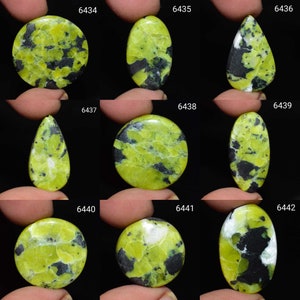 May include: Ten green and black gemstone cabochons, each with a unique pattern. The cabochons are in various shapes, including round, oval, and teardrop.