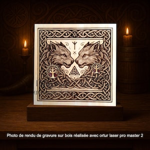 Może przedstawiać: Drewniana tablica z laserowo grawerowanym wzorem dwóch wilków zwróconych do siebie, otoczonych skomplikowanymi węzłami. Grafika zawiera symbole i emblemat drzewa życia. Tablica jest zamontowana na ciemnej drewnianej podstawie.