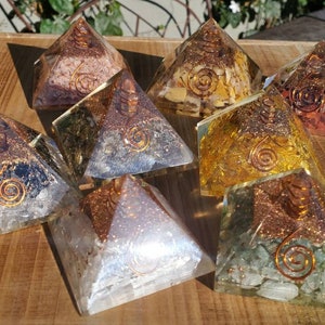 K&ouml;nnte beinhalten: Acht Kristallpyramiden mit Kupferspiralen. Die Pyramiden bestehen aus verschiedenen Kristallen, darunter klarer Quarz, Amethyst, Rosenquarz, Citrin und gr&uuml;ner Aventurin.