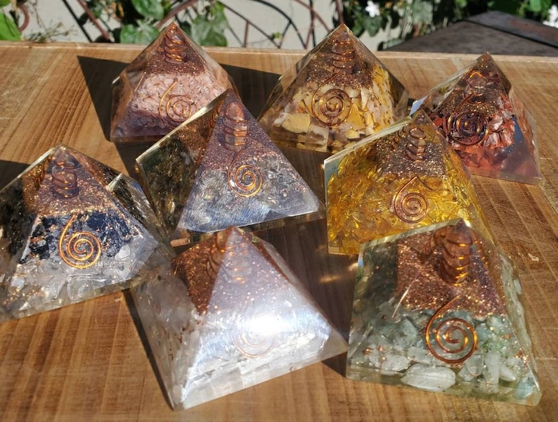 K&ouml;nnte beinhalten: Acht Kristallpyramiden mit Kupferspiralen. Die Pyramiden bestehen aus verschiedenen Kristallen, darunter klarer Quarz, Amethyst, Rosenquarz, Citrin und gr&uuml;ner Aventurin.