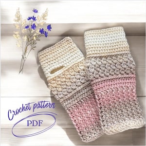 May include: A pair of handmade crochet fingerless gloves in a gradient of beige, tan, and pink. The gloves feature a textured stitch pattern and a thumb opening. The words "Crochet pattern PDF" are written in a cursive font.