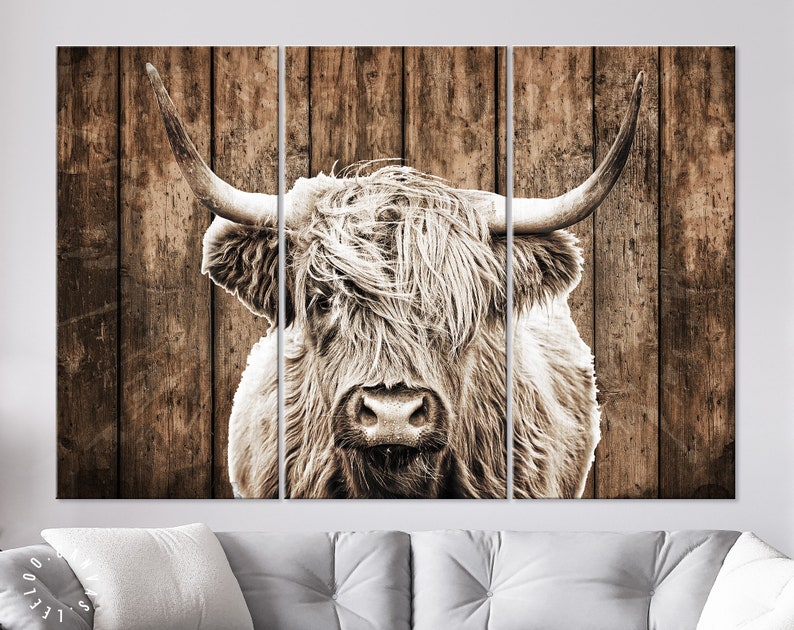 May include: A black and white photograph of a Highland cow with long, shaggy hair, set against a rustic wooden background.