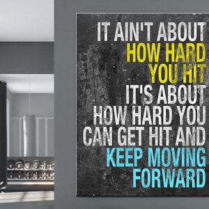 May include: A motivational quote on a black and gray textured background. The quote reads "It ain't about how hard you hit. It's about how hard you can get hit and keep moving forward". The words "how hard you hit" are in yellow and the words "keep moving forward" are in blue.