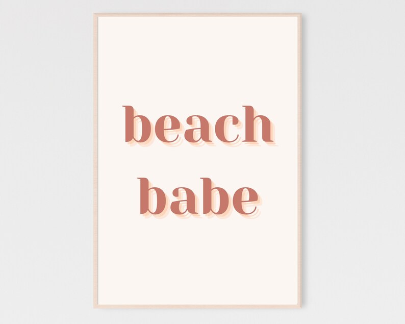 Puede incluir: Un fondo blanco con el texto "beach babe" en un color rosa melocot&oacute;n con un efecto de sombra.