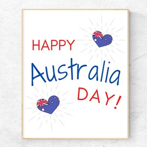 K&ouml;nnte beinhalten: Eine wei&szlig;e Karte mit dem Text "Happy Australia Day!" in roten und blauen Buchstaben. Zwei blaue Herzen mit der australischen Flagge befinden sich auf der Karte.