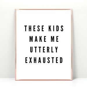 Könnte beinhalten: Gerahmter Druck mit weißem Hintergrund und schwarzem Text, der lautet: "THESE KIDS MAKE ME UTTERLY EXHAUSTED." Der Rahmen ist roségoldfarben.