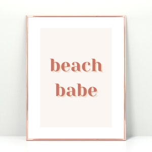 Puede incluir: Una impresi&oacute;n enmarcada con un fondo melocot&oacute;n y el texto "beach babe" en un color melocot&oacute;n rosado.