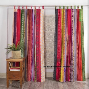 Peut inclure: Une paire de rideaux colorés fabriqués à partir de tissu de sari recyclé. Les rideaux sont composés de bandes verticales de tissu dans différentes nuances de rouge, violet, vert, jaune et bleu. Le tissu présente des motifs et des designs complexes. Les rideaux sont suspendus à une tringle en métal et sont prêts à ajouter une touche de style bohème à n'importe quelle pièce.