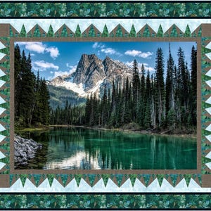 May include: A framed photograph of a mountain lake surrounded by a lush forest. The lake is a vibrant green and reflects the blue sky and white clouds. The mountains in the background are snow-capped and rugged.