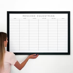 Może przedstawiać: Biała tablica z czarną ramą i tekstem "RESCHKE EQUESTRIAN" u góry. Tablica jest podzielona na kolumny z nagłówkami: "Jeździec", "Koń", "Dywizja", "Czas przygotowania", "Czas jazdy" i "Uwagi".