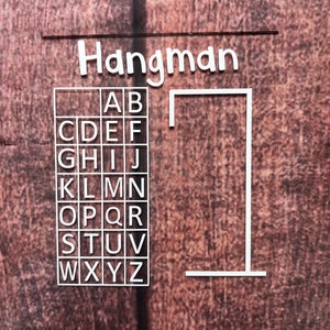 May include: A white Hangman game board with a grid of letters A through Z and a blank gallows. The board is on a brown textured background.