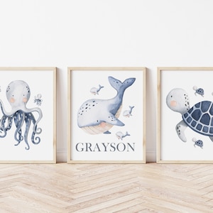 May include: Three watercolor prints featuring a blue octopus, a whale, and a turtle. The whale print includes the name Grayson.