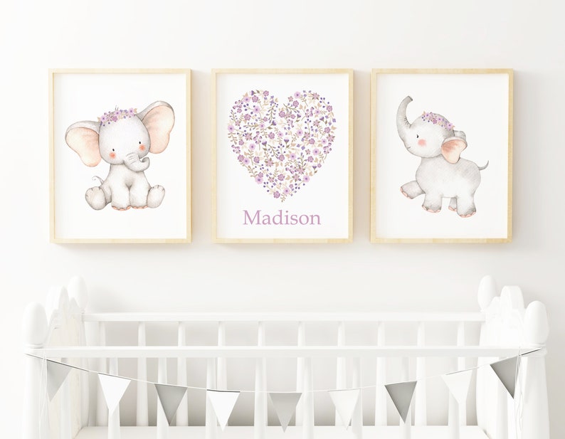 May include: Three framed prints with a watercolor illustration of a cute elephant with a purple flower crown. The middle print features a heart shape made of purple flowers with the name "Madison" written below.