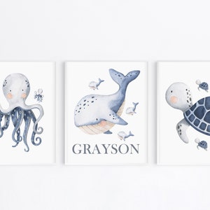 May include: Three watercolor illustrations of sea creatures. The first shows a blue octopus with eight tentacles. The second shows a blue whale with a light blue belly and the name Grayson. The third shows a blue sea turtle with a light blue shell.