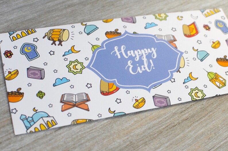 May include: A white card with a blue and white banner that says "Happy Eid!" The card is decorated with a pattern of colorful Islamic symbols, including crescent moons, stars, mosques, and lanterns.